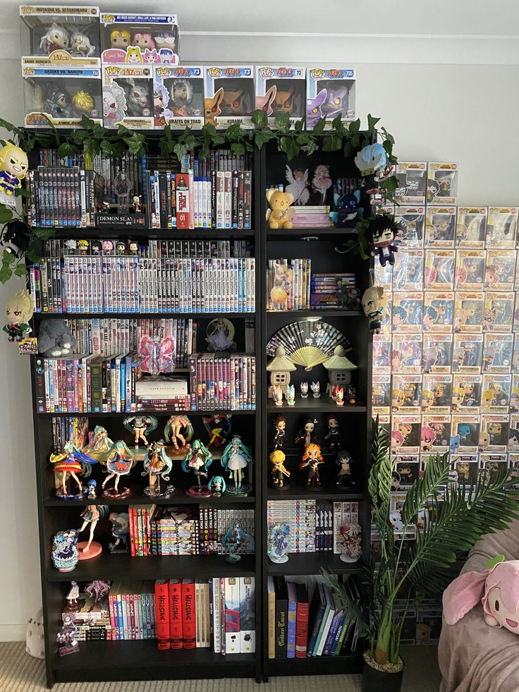 a book shelf filled with lots of books and anime figurines next to a bed