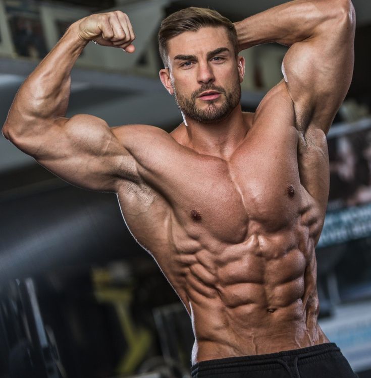 a man flexing his muscles in the gym