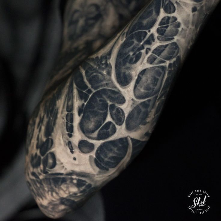 a man's arm covered in black and white ink with an animal paw print on it