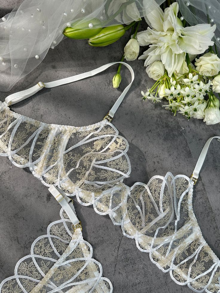 Introducing "Heavenly Glow Radiance Luxe Lingerie Set," a celestial blend of white satin and golden thread embroidery, creating an ethereal lingerie experience. Elevate your moments with the divine touch of opulence. ✨ ✨ Material: Made of 90% Polyester, 10% Elastane. Exquisite Embroidery Design: The lingerie set features intricate embroidery, adding delicate patterns for an alluring appeal. Comfortable and Form-Fitting: Lightweight Padded-free Underwire Bra. Crafted from soft and smooth fabric, Elegant String Bra For Wedding, Elegant String Wedding Bra, Elegant Wedding String Bra, White Sheer Bra For Party, Sheer White Party Bra, White Sheer Party Bra, Sheer White Wedding Bra, White Sheer Wedding Bra, Ethereal Lingerie