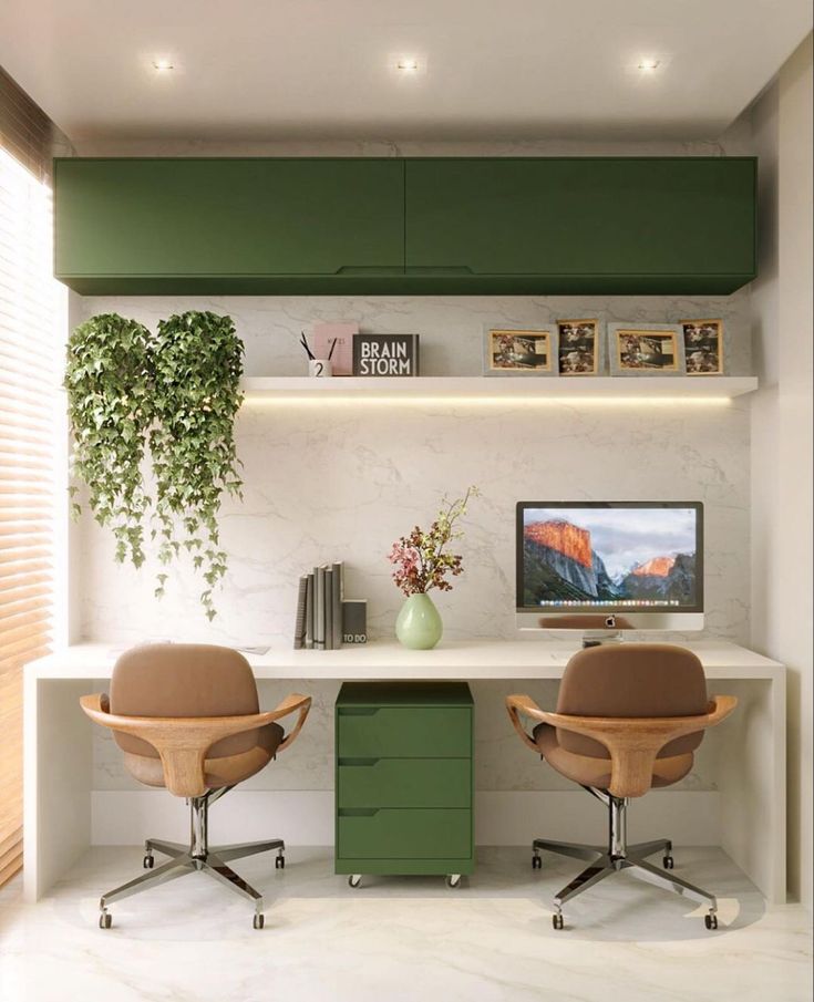 two office chairs sitting in front of a desk with a computer monitor on top of it