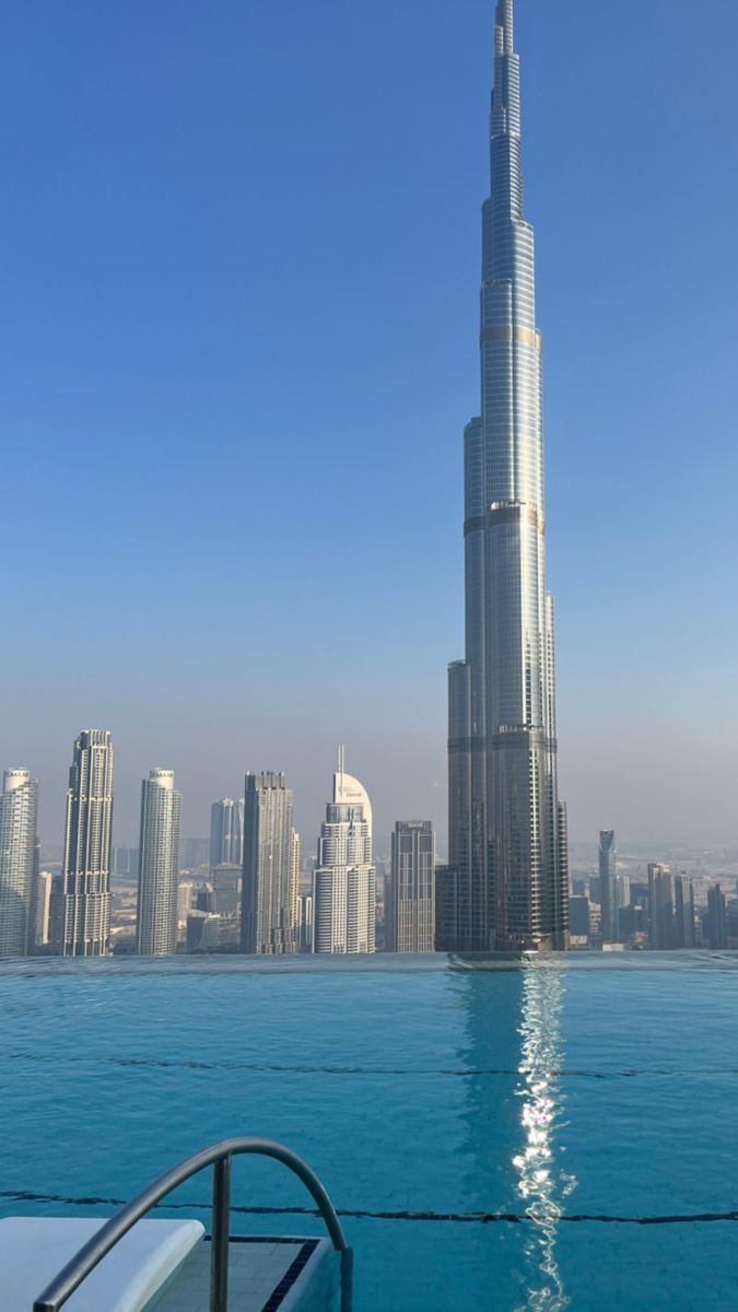 the burj tower towering over the city skyline is seen from across the water