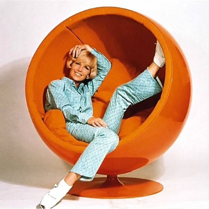 a woman sitting in an orange ball chair