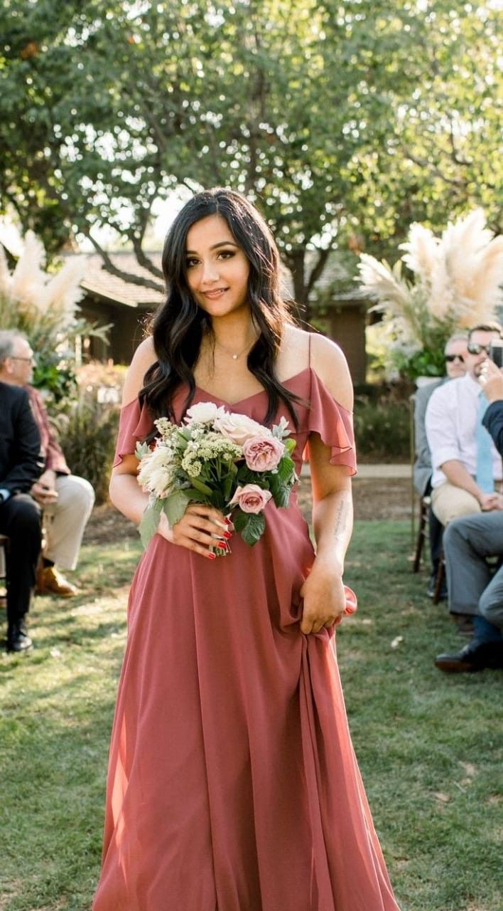 a woman in a long dress holding a bouquet