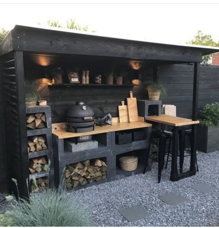 an outdoor kitchen made out of pallets and firewood is seen in this image