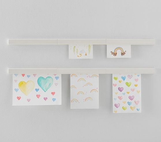 several cards hanging on a wall with hearts and rainbows