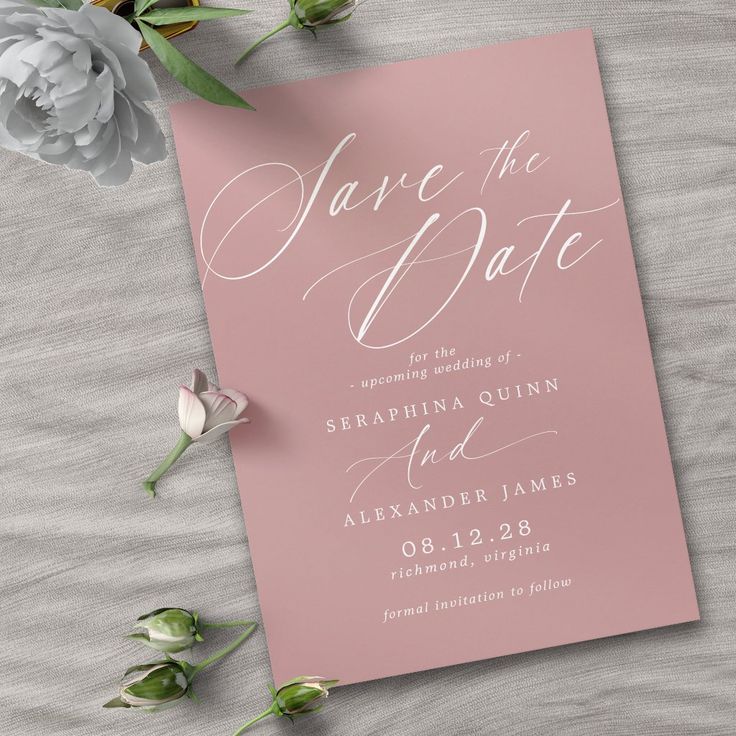 a pink save the date card next to flowers