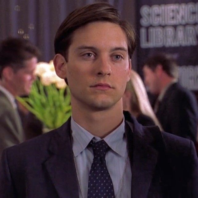 a young man in a suit and tie looking at the camera