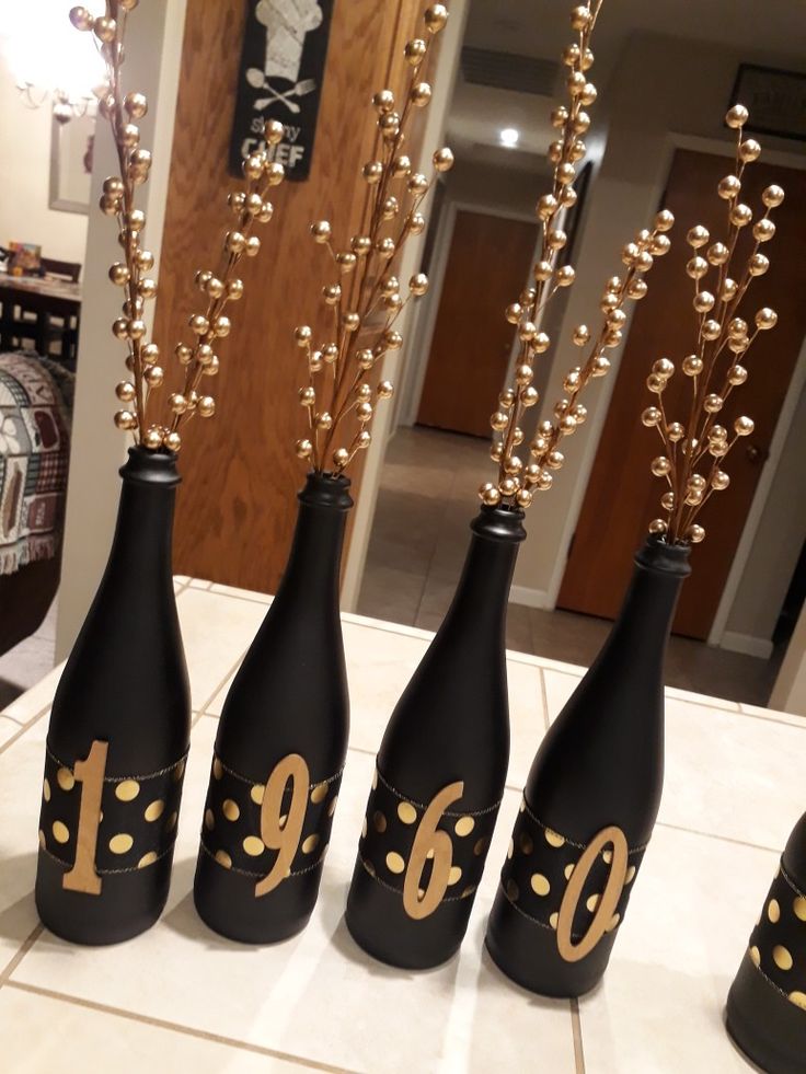 four black bottles with gold numbers on them