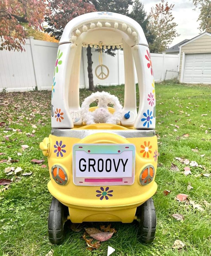 a yellow toy car with a white teddy bear in it's seat and the word groovy written on the front