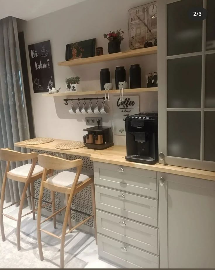 two chairs are sitting at the counter in this kitchen with open shelving and coffee maker