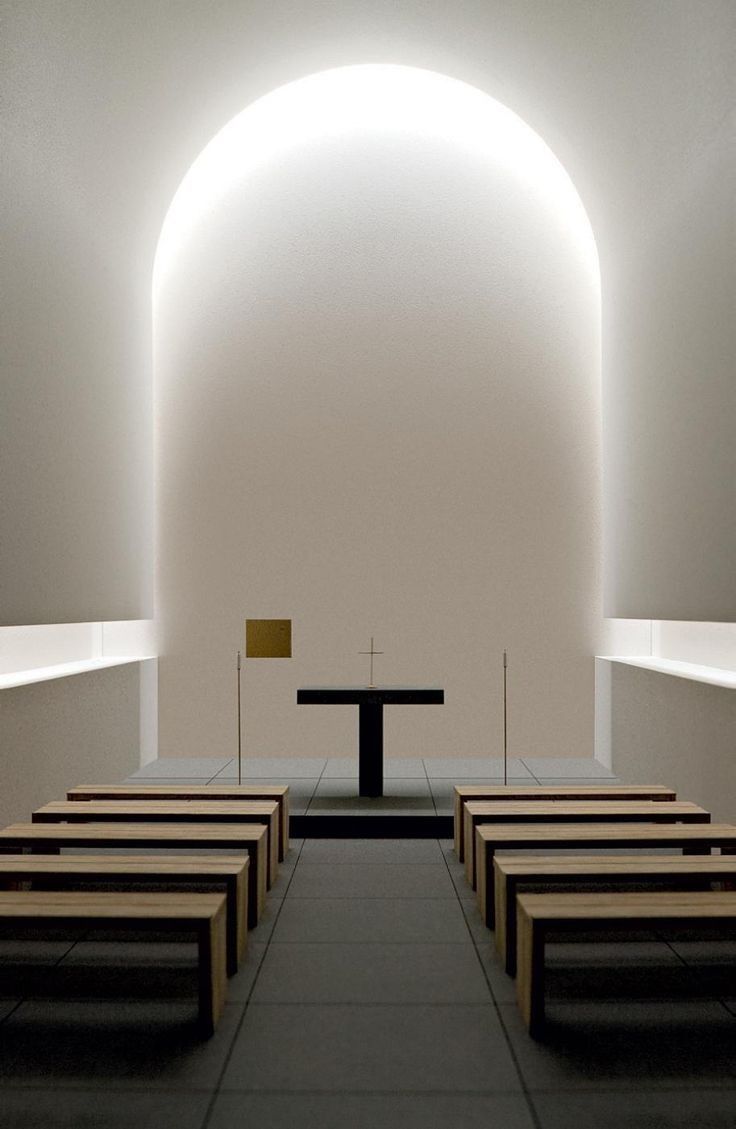 an empty church with rows of pews and a cross at the end in front of it