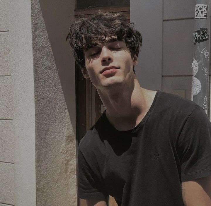 a young man standing in front of a building