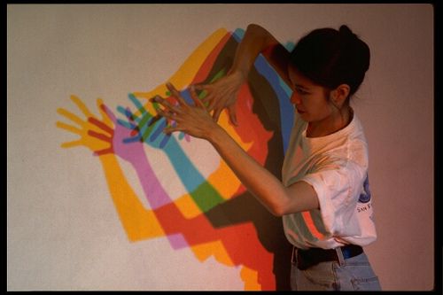 a woman is painting on the wall with her hands