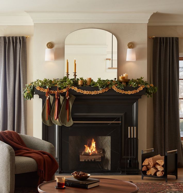 a living room filled with furniture and a fire place in front of a mirror on the wall