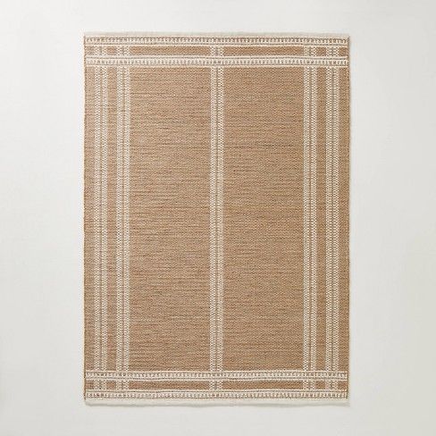 a beige and white rug hanging on the wall