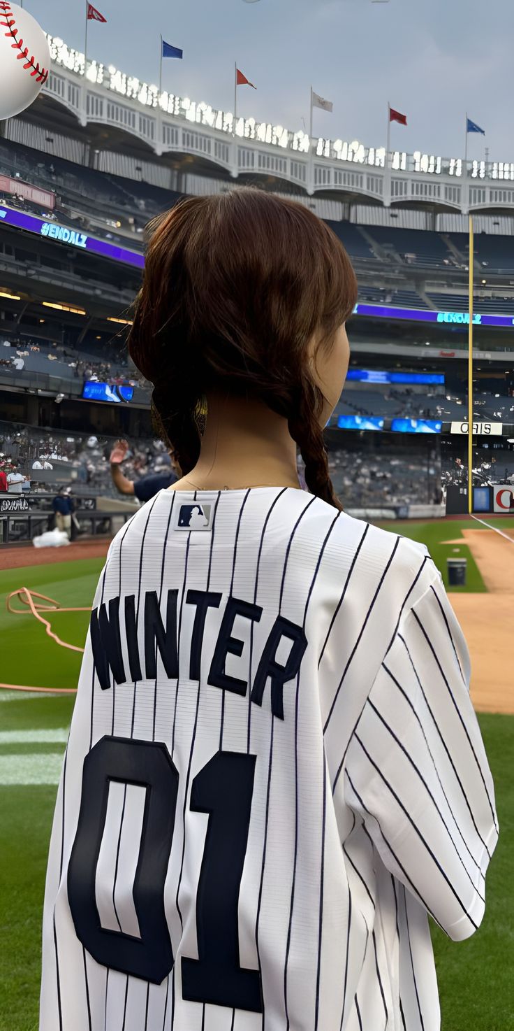 a woman in a baseball uniform at a game