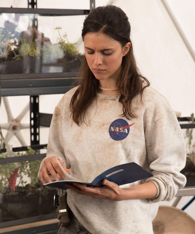 a woman is holding a book and looking at it