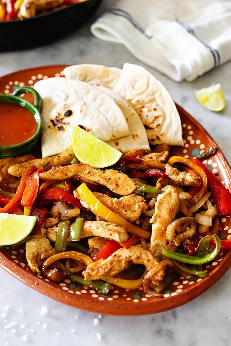 a plate filled with chicken fajita and tortillas