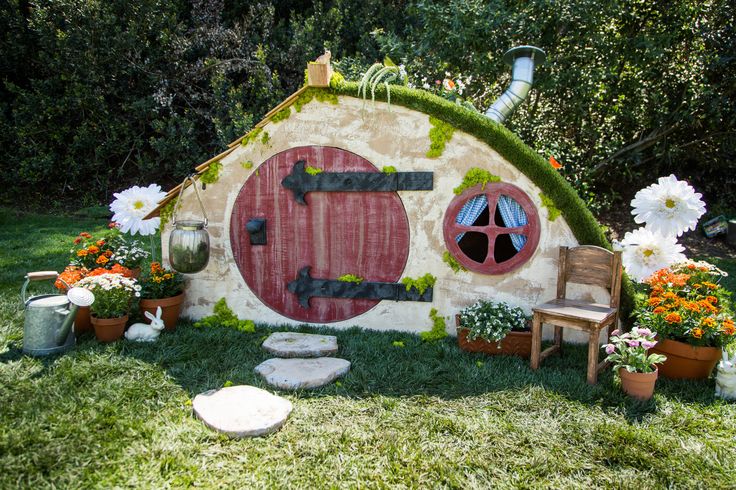 a hobbot house with flowers and potted plants in the front yard area