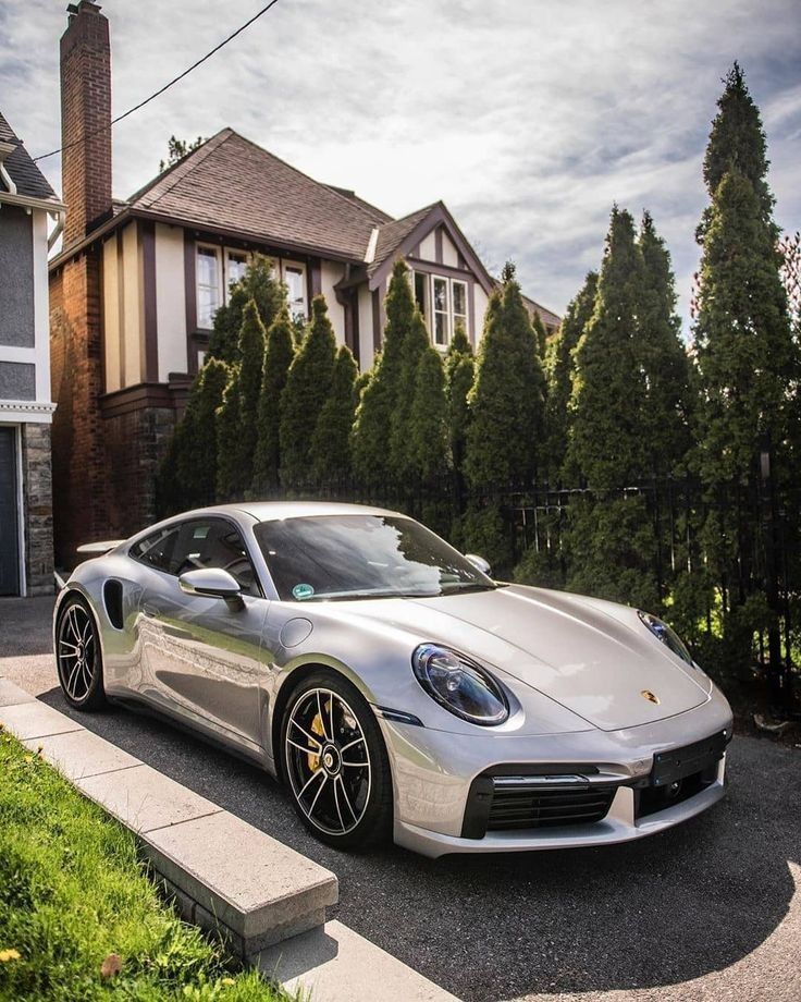 a silver sports car parked in front of a house