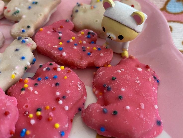 there are many cookies on the plate with sprinkles and decorations around them