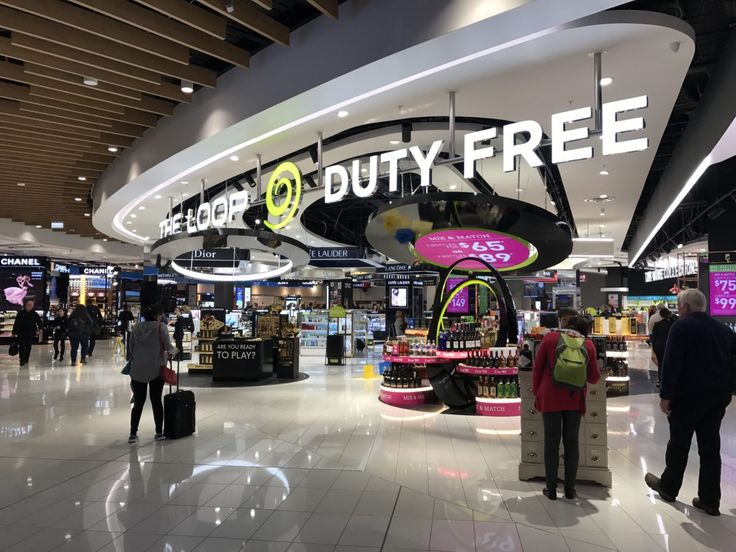 people are standing in the lobby of a duty free store