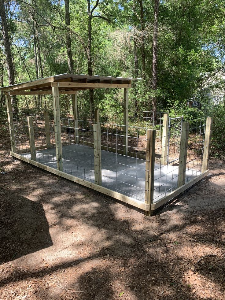 a wooden shelter in the middle of a forest with metal bars on it's sides