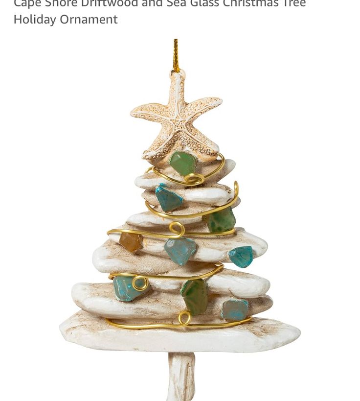 a christmas tree made out of rocks with starfish and shells on the top is shown