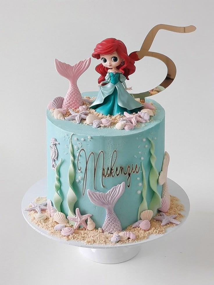 there is a cake with a little mermaid on it