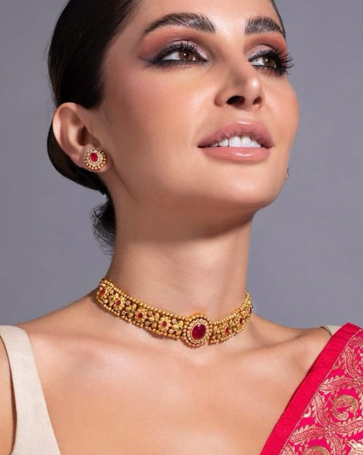 * 24K Gold Plated Handcrafted Intricate Choker Jewellery Set * Gold plated necklace, has a drawstring closure * Gold plated earrings, has a post and back closure * Size:- Necklace length: 25.3 cm Earrings length: 1.6 cm(each) *Material:- Material: Brass Plating: Gold-Plated Stone Type: CZ, Ruby stones and beads NOTE All the raw material used in this product is of high quality and is handcrafted with love. Premium Quality and High craftsmanship 100% Satisfaction Guarantee: Long Lasting Plating, H Kundan Gold Choker For Puja, Festival Choker With Latkans For Gift, Festival Temple Choker Necklace For Celebration, Festival Gift Choker With Latkans, Festival Latkans Choker As Gift, Festive Gift Choker With Latkans, Gold Cutdana Choker Necklace, Festive Celebration Choker With Latkans, Ruby Choker Necklace