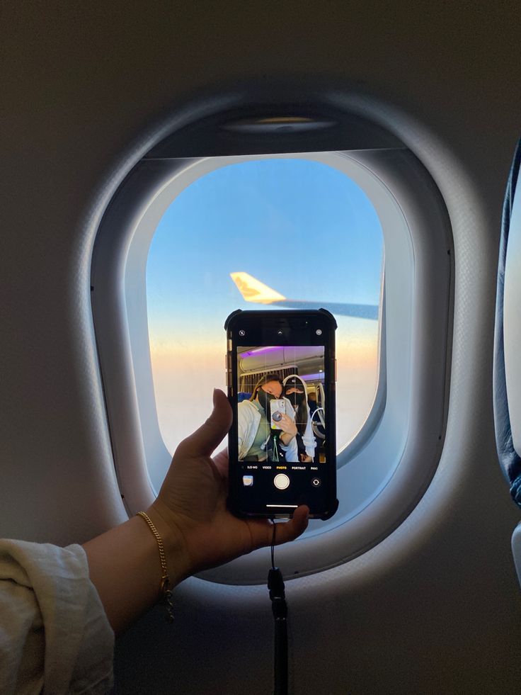 a person taking a photo of an airplane window