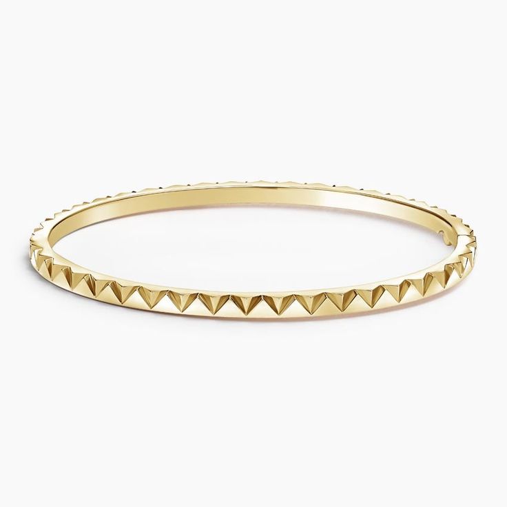 a gold bracelet with pyramids on it