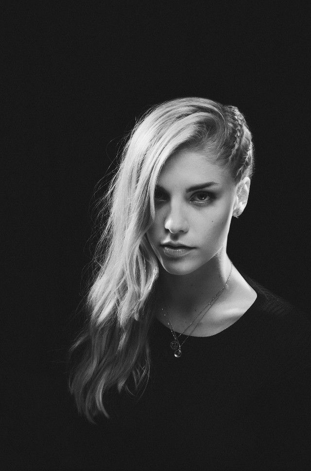 a black and white photo of a woman with long hair, wearing a choker