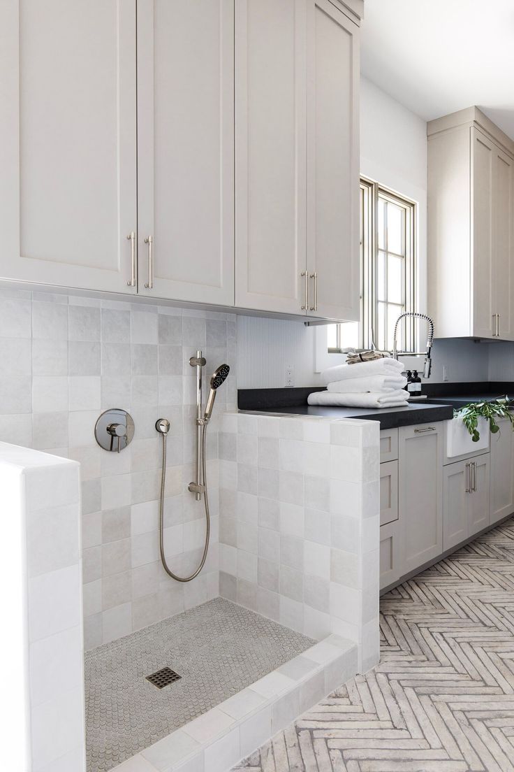 a kitchen with white cabinets and black counter tops