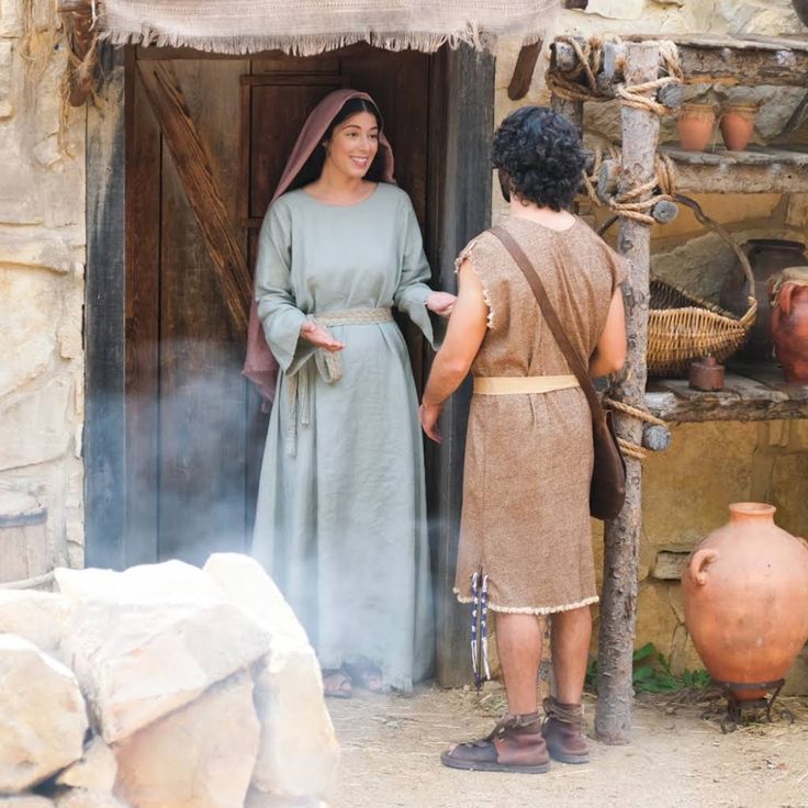 two people standing in front of a door with pots on the outside and one person wearing a dress