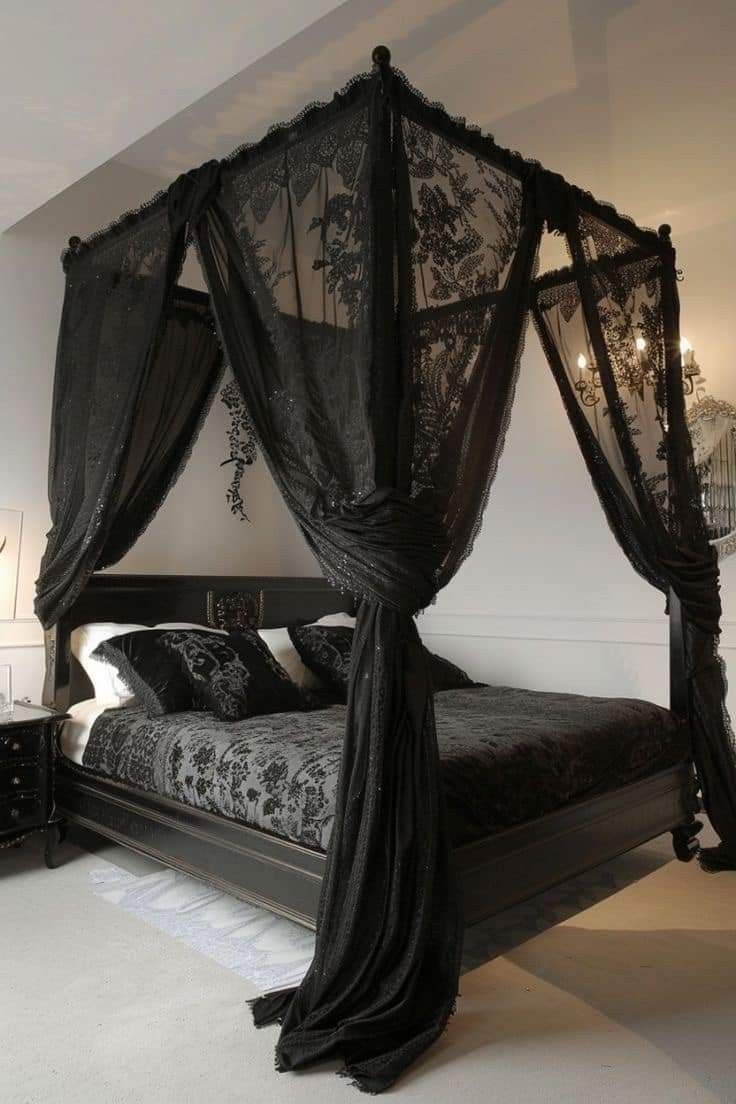 a black canopy bed in a white bedroom