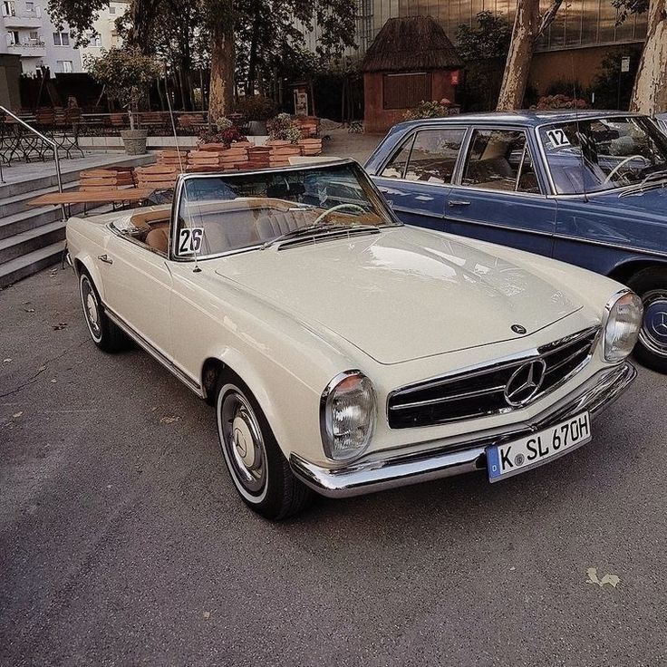 two old cars parked next to each other on the street