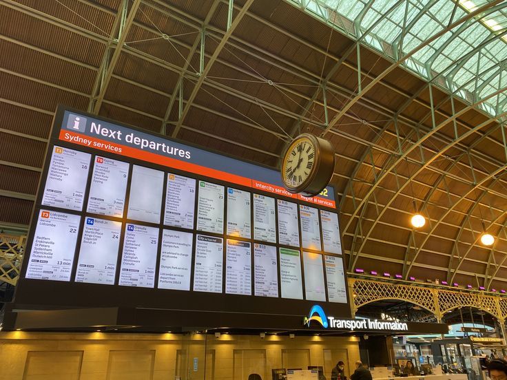 a large screen in the middle of a train station