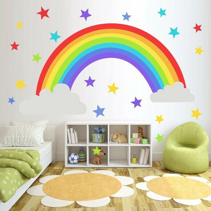 a child's room with a rainbow wall decal and stars on the wall