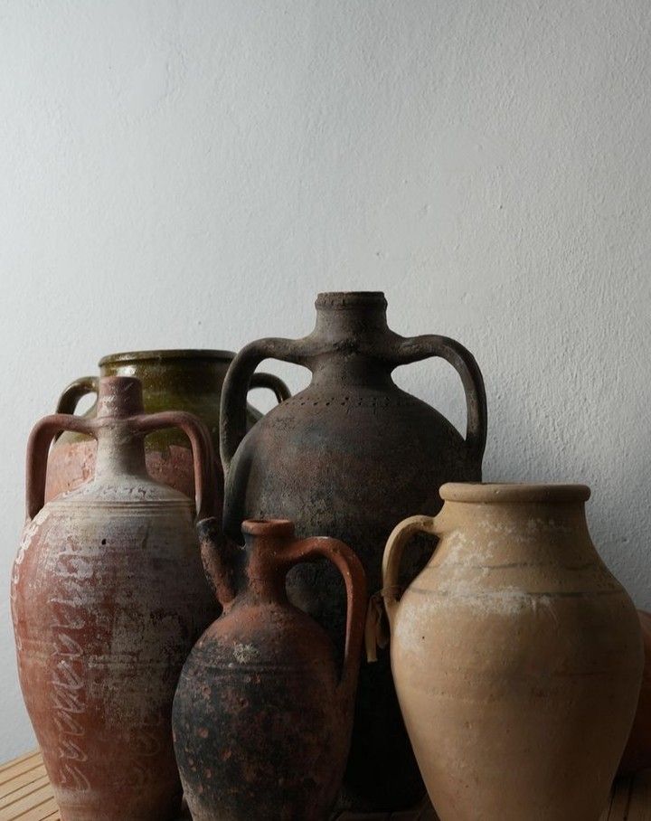 four vases sitting on top of a wooden table