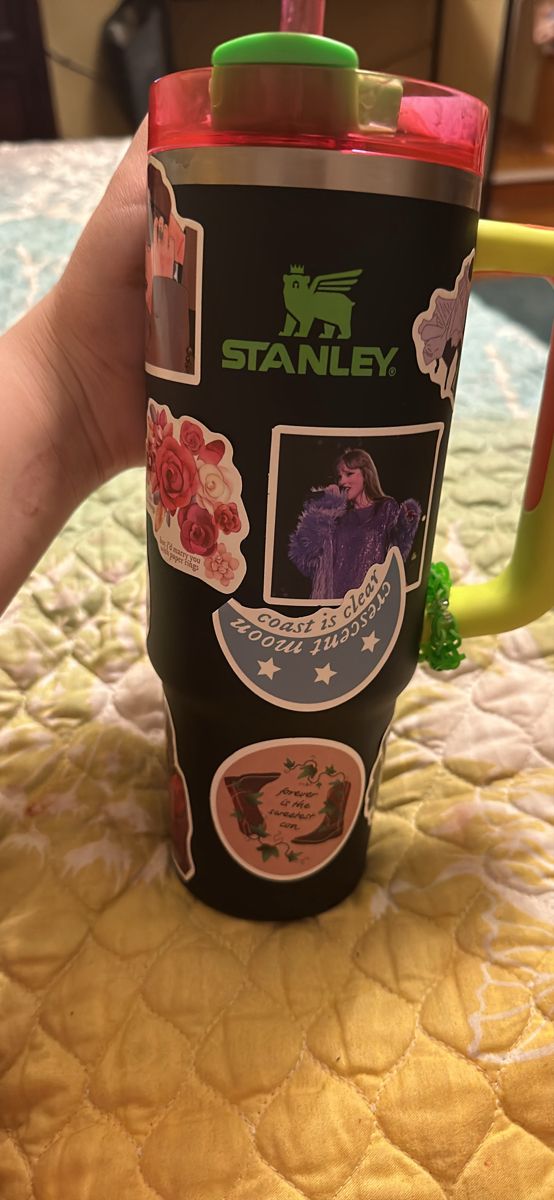 someone holding up a travel mug with pictures on it