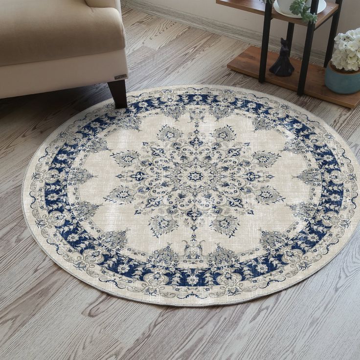 a white and blue rug on the floor in a living room with a beige chair