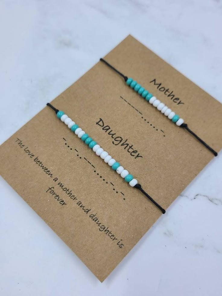 two blue and white beaded bracelets sitting on top of a card