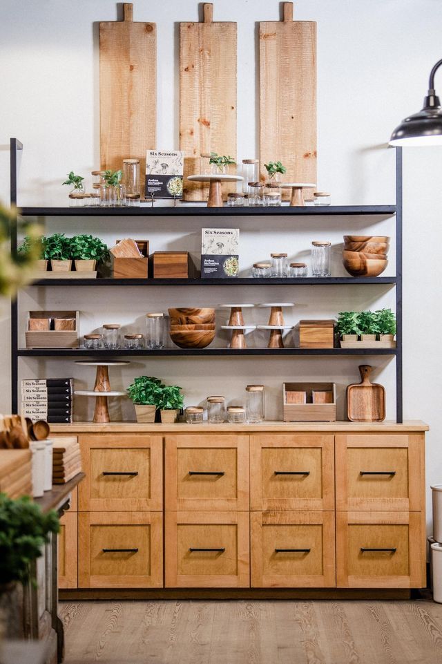 a kitchen with wooden cabinets and shelves filled with food