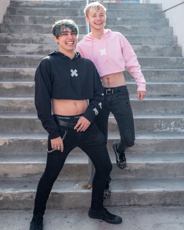 two young men standing on the steps in front of some stairs