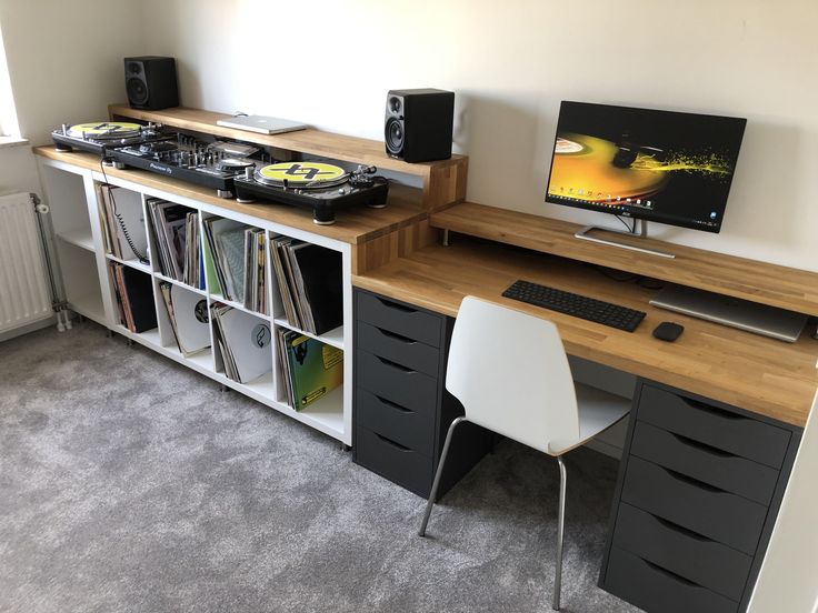 a room with a desk, bookshelf and speakers