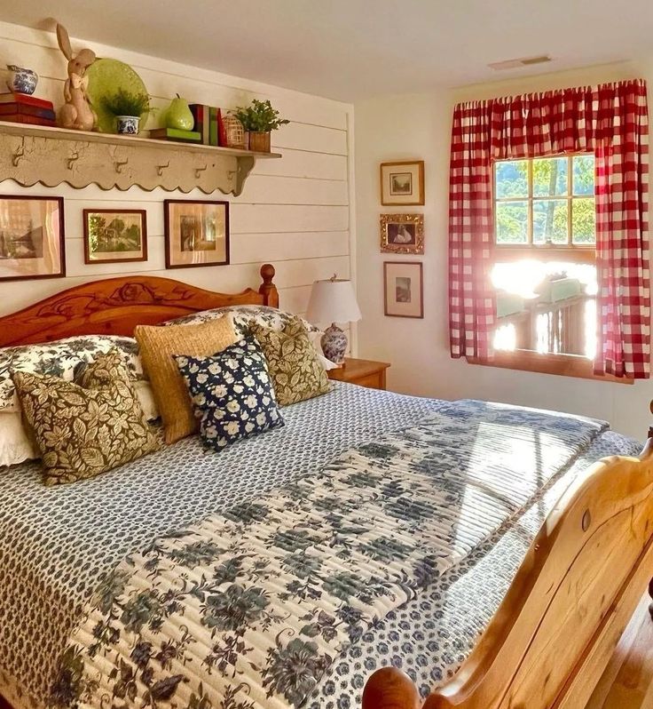 a large bed in a bedroom next to a window with red and white checkered curtains