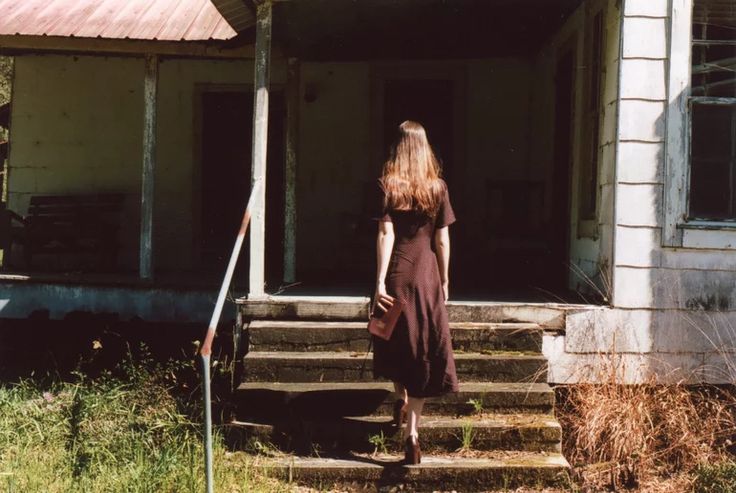 a woman is walking up the steps to her house