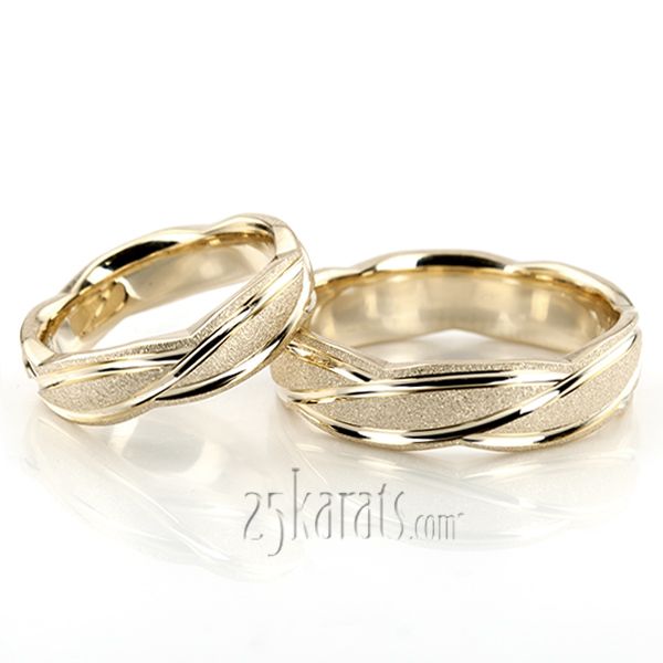 two gold wedding rings sitting next to each other